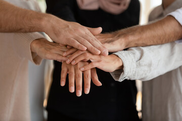 Like-minded people, business partners associates stacked palms together, touch hands feeling unity showing companionship, close up. Symbol of gender equality, shared success, loyalty, support concept