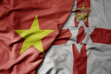 big waving realistic national colorful flag of vietnam and national flag of northern ireland .