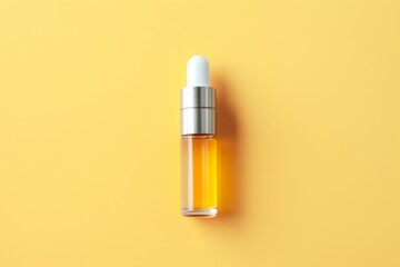 mock-up of transparent cosmetics bottle with dispenser for essential oil or perfume, bottle with pipette on yellow background, aromatherapy, top view