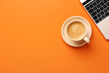 White cup of latte coffee with foam and slightly visible laptop on orange background with empty space for text, graphic or product, top view.generative ai
