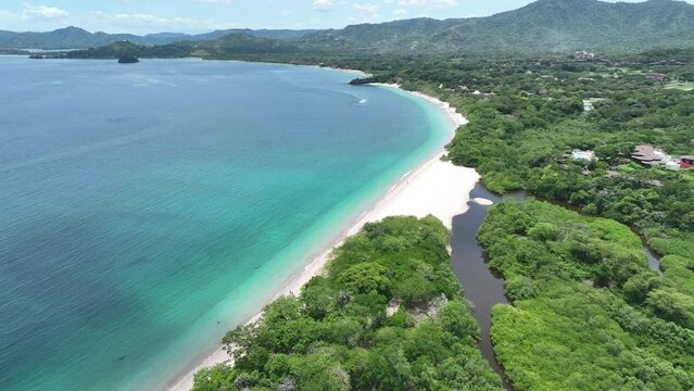 Playa Conchal, in Guanacaste, Costa Rica, is a stunning beach known for its unique seashell-covered shores, crystal-clear waters, and lush surroundings, perfect for a tropical escape.