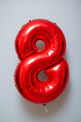 red foil number 8 balloon on white background