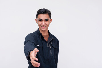 A good looking young Filipino man introducing himself to someone, offering a handshake. Isolated on a white background. - obrazy, fototapety, plakaty
