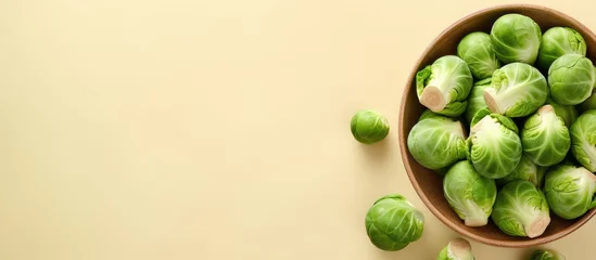 Foto op Aluminium Fresh Brussels sprouts on a isolated pastel background Copy space from above © HN Works