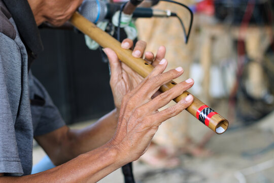 People blow or play bamboo flutes to accompany dangdut music