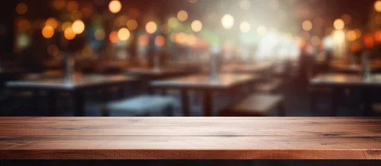  Wood table top with blurred restaurant background for displaying or assembling products © AkuAku