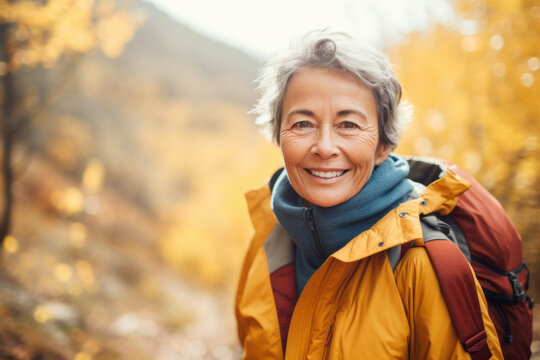 Portrait of mature senior woman hiking in autumn forest , concept of travel lifestyle adventure active vacations outdoor and healthy with fall leaves colors