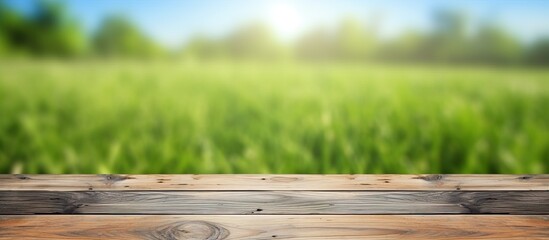 Fototapeta premium Empty wooden planks against a nature backdrop of grass and sky
