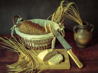 Rustic still life in antique style with bread and ears of wheat . - 651621953