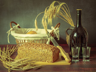 Rustic still life in antique style with bread and ears of wheat . - 651622104