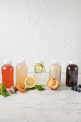 Assorted Bottles of fresh infused water with fruits on white background. Copy space. Vertical
