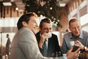 Middle aged male business friends having coffee after work in a caf? decorated for Christmas and the new year holidays