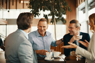 Diverse group of business friends having coffee after work in a caf? decorated for Christmas and the new year holidays