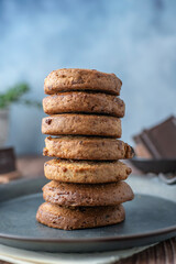 American cookies with chocolate pieces on a blue cloth napkin and an aluminum plate with iron handles.