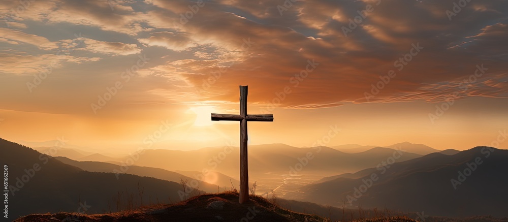 Wall mural Artistic silhouette of a crucifix cross against a sunset sky showcasing mountain majesty