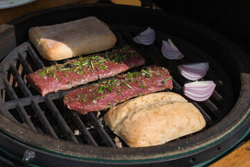 outdoor grilling venison meat from a chamois on the charcoal grill with bread and red onions at  sunny autumn day