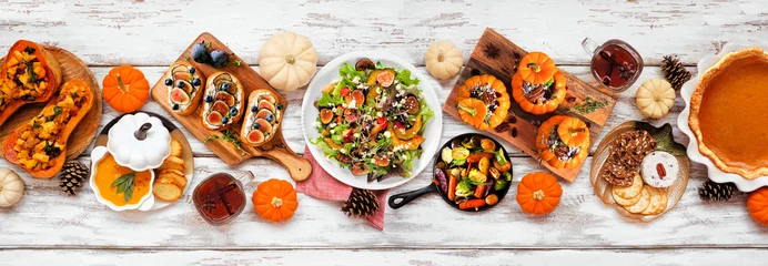 Foto op Plexiglas Delicious autumn meal table scene. Overhead view on a white wood banner background. Stuffed pumpkins and squash, sweet potatoes, appetizers, soup, vegetables and pumpkin pie. © Jenifoto