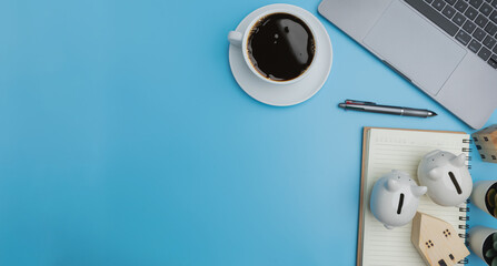 Investment, Accounting, Financial concept. Top view, Save money investment estate. Flat lay a laptop, coffee of a white cup, with two piggybanks on blue background with copy space.