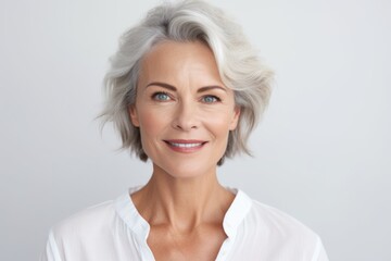 Fototapeta premium Happy 50s middle aged woman model touching face skin looking in mirror reflection. Smiling mature old lady pampering, healthy moisturized skin care, aging beauty, skincare treatment cosmetics concept