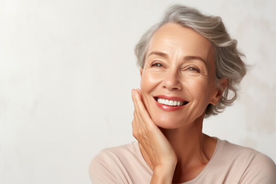 Happy 50s middle aged woman model touching face skin. Smiling mature old lady pampering, healthy moisturized skin care, aging beauty, skincare treatment cosmetics concept. Copy space. Website images