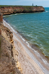 Steep clayey and shell rock shore overgrown with wild steppe vegetation on the island of Berezan, Ukraine