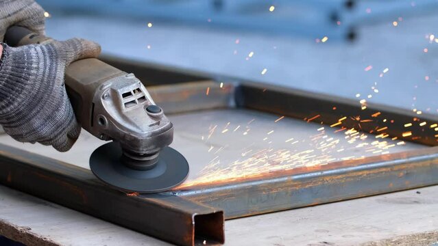 Grinding machine at work. Sparks fly from under the grinders, men's work. Dark background with copy space.