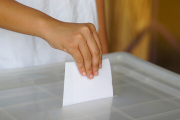 Hand drops a ballot into a box. Soft and selective focus. In the concept of voting system, voting, election, Members of the House of Representatives vote.