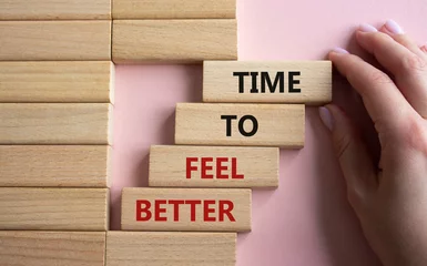 Fotobehang Time to feel better symbol. Wooden blocks with words Time to feel better. Businessman hand. Beautiful pink background. Medicine and Time to feel better concept. Copy space. © Natallia