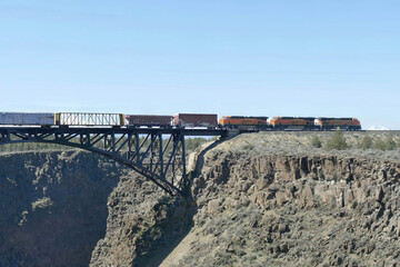 Freight train crosses steel bridge over Crooked River gorge
