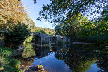 Fototapeta na wymiar An old stone footbridge across the river Creuse at Fresselines.