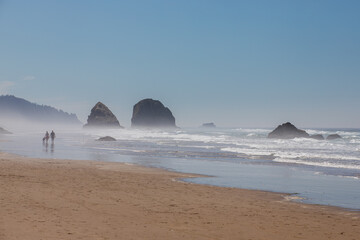Cannon Beach Oregon USA - August 21, 2023 - couple walks along the beach