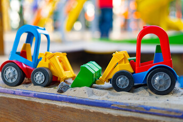 Fototapeta premium Multi-colored children's toy car bulldozer on the playground. Selective focus