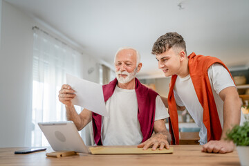 Senior man grandfather and caucasian man teenager boy grandson receive letter read good news...