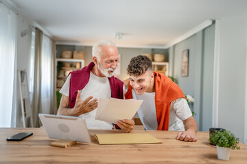 Senior man grandfather and caucasian man teenager boy grandson receive letter read good news...