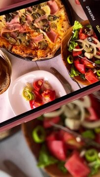 taking photos of food on social. networks with iPhone pizza caesar salad bread on the table restaurant teenagers New generation of gadget phones video upright girl useful food