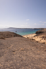 Natural white sandy beach landscape. Cove. Papagayo beach, Lanzarote. Beach and cliff. Turquoise ocean waters. Clear sky. Canary Islands, Spain