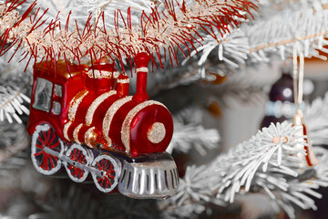 Red train as Christmas tree decoration against white branches - 651713708