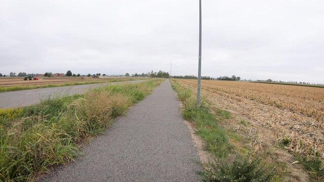 Via Francigena - a country road through agricultural fields being cultivated after Pontenure, Province of Piacenza, Emilia-Romagna, Italy