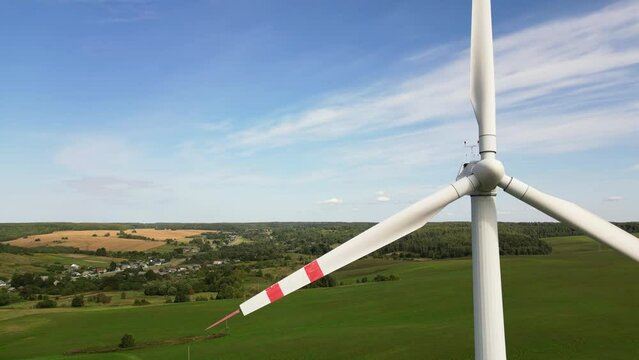 Aerial view of a windmill against the sky. Flying a drone near the blades of a wind turbine. Renewable energy, eco friendly. Rising electricity prices in Europe