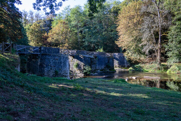 Fototapeta na wymiar An old stone footbridge across the river Creuse at Fresselines.