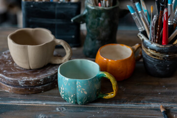 Handmade craft mugs in the pottery