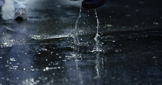 Rainboot Revelry - Kid's Delightful Jumps in Puddles Create Splashing Spectacle, Caught in High-Speed Slow-Motion