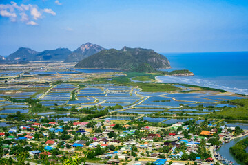 Aerial panorama of Thailand's Khao Sam Roi Yot National Park, there is a well-known tourist destination with views of the sea, limestone mountain, and a farm. - Powered by Adobe