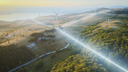 Wind mill turbine park station for clean green energy production, electric car driving on a road -...