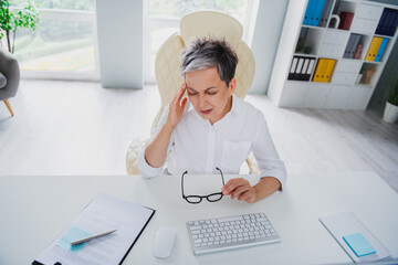 Photo of stressed unhappy lady assistant wear white shirt feeling headache indoors workplace workshop