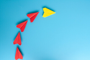 Top view of yellow paper plane origami leading red paper planes. With copy space for text