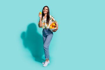Photo of adorable lovely girl wear stylish clothes hand showing delicious mandarin tasty juice isolated on cyan color background