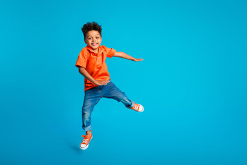 Obraz premium Full length cadre photo of careless little funny schoolboy atmosphere hands do dab sign cool dancer isolated on blue color background