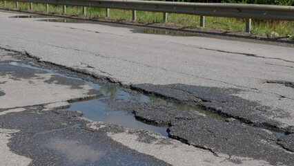 Potholes on bad asphalt road. Closeup. Nobody