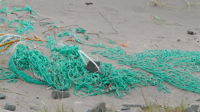 45441_A_green_fishing_net_scattered_on_the_shore.mov